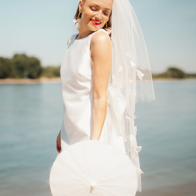Braut vor Rhein bei Brautshooting mit Sonnenschirm